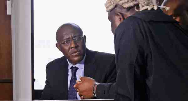 Olisa Metuh strategising with his legal council in court